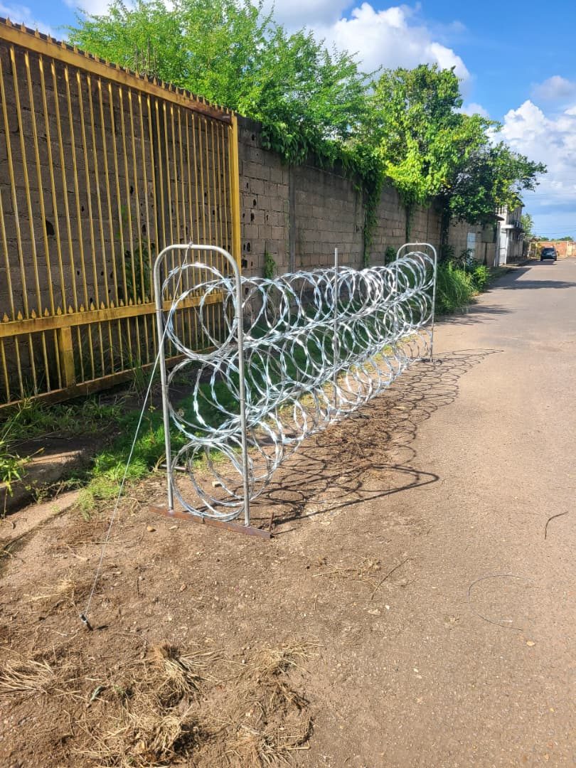 Concertina instalada sobre soportes metálicos junto a un muro perimetral