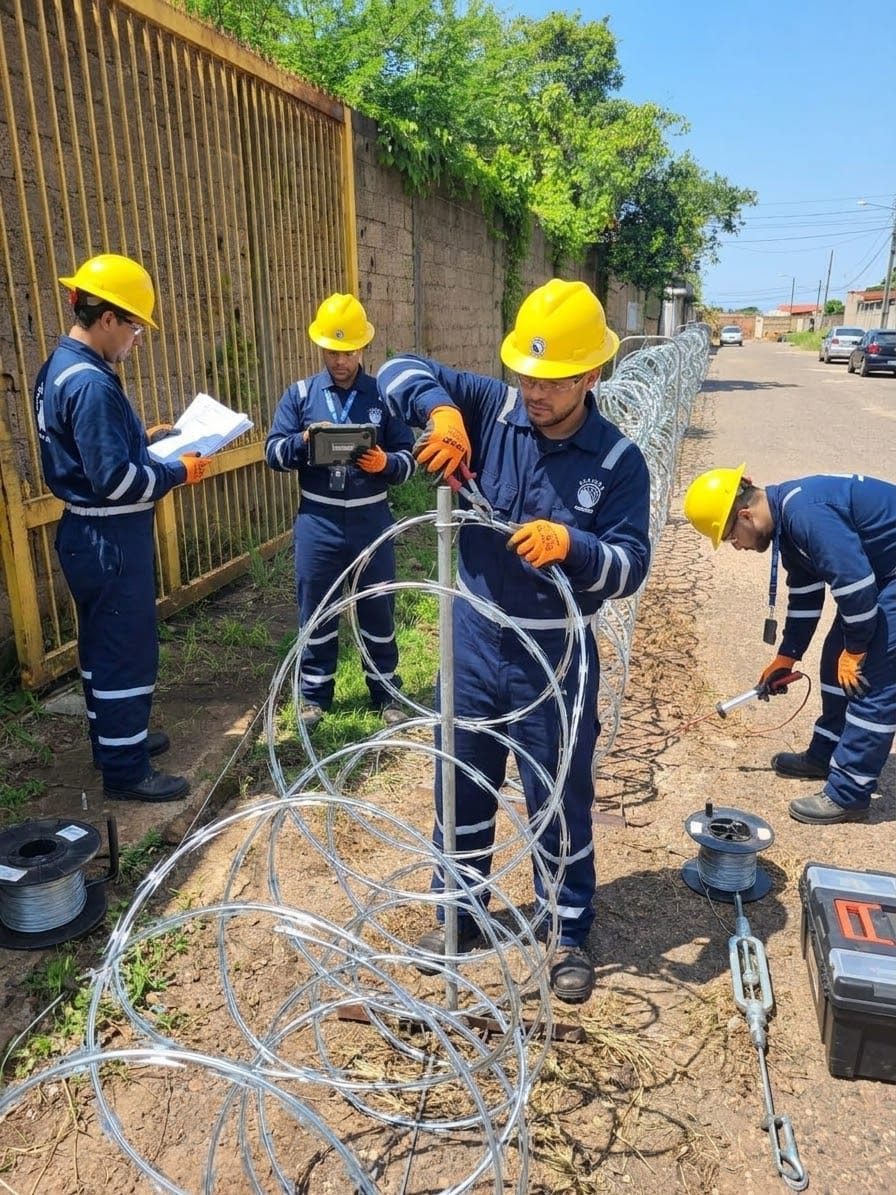 Cuadrilla técnica desplegando concertina junto a un muro perimetral
